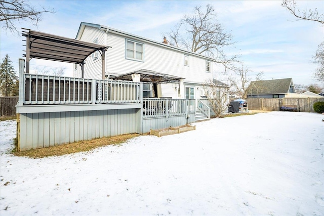 snow covered house featuring a wooden deck and a gazebo