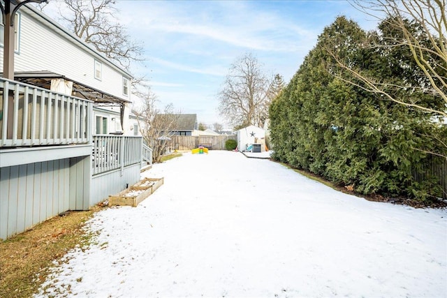 yard covered in snow featuring a wooden deck