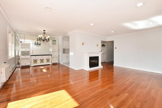 unfurnished living room with a notable chandelier, crown molding, and wood-type flooring