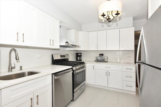 kitchen featuring sink, wall chimney range hood, white cabinetry, stainless steel appliances, and tasteful backsplash