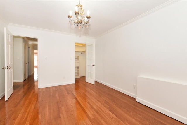 unfurnished bedroom featuring crown molding, wood-type flooring, and an inviting chandelier