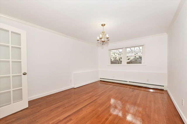 unfurnished room with a baseboard radiator, wood-type flooring, a notable chandelier, and ornamental molding