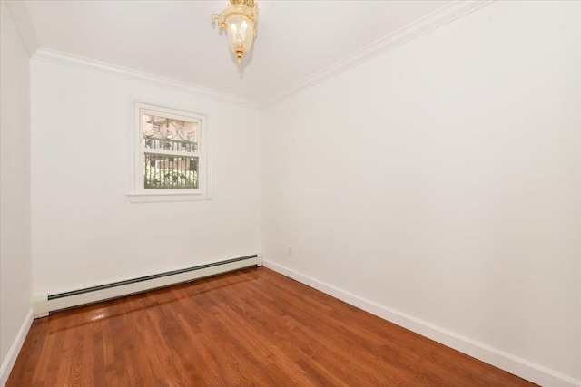 spare room with ornamental molding, hardwood / wood-style floors, and baseboard heating