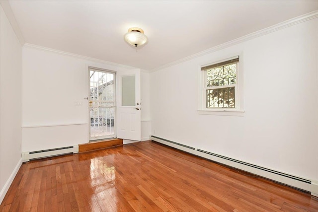 spare room featuring hardwood / wood-style floors, a baseboard radiator, and ornamental molding