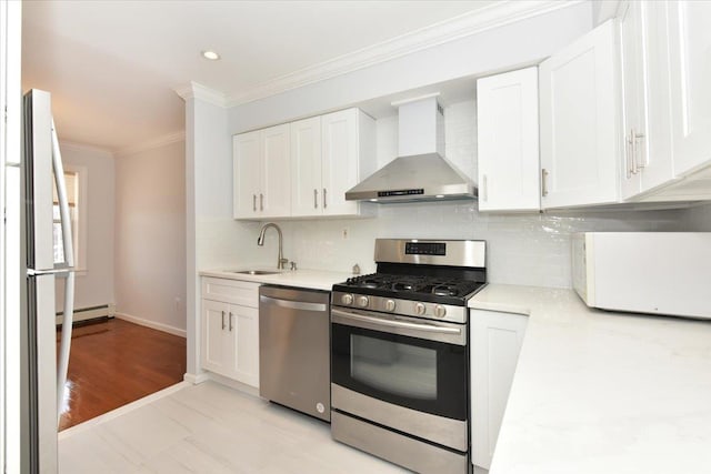 kitchen featuring white cabinets, crown molding, stainless steel appliances, and wall chimney exhaust hood