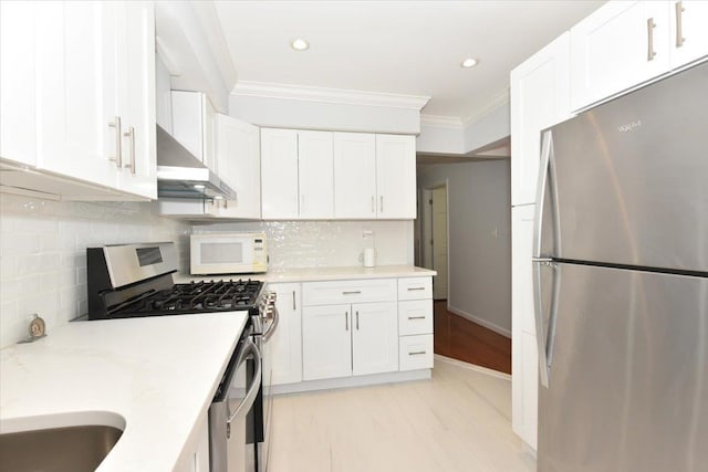 kitchen featuring white cabinetry, appliances with stainless steel finishes, and crown molding