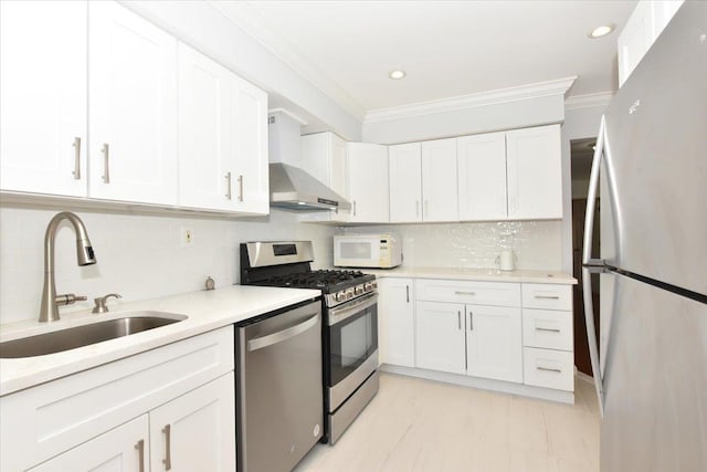 kitchen featuring sink, crown molding, stainless steel appliances, and white cabinets