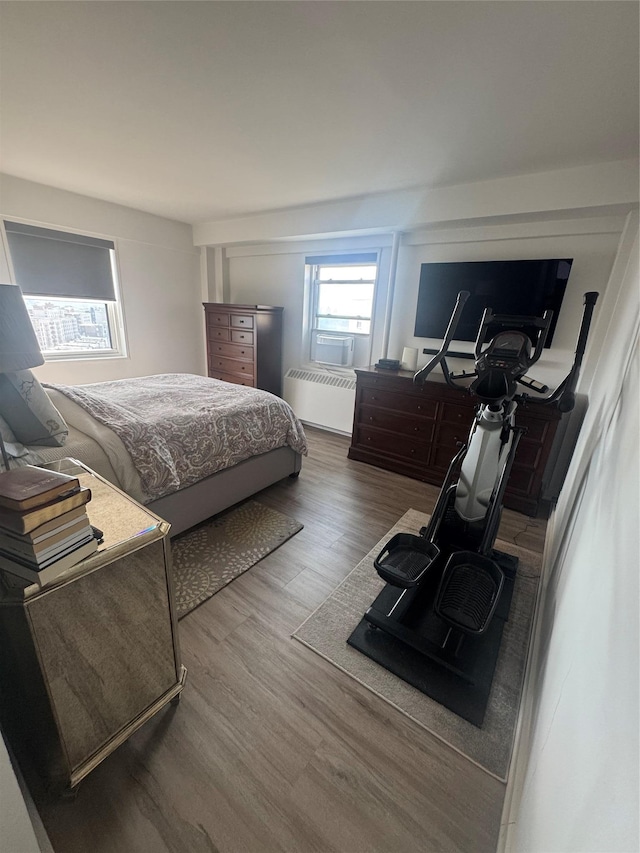 bedroom with radiator and hardwood / wood-style floors