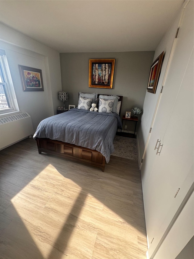 bedroom with radiator and light wood-type flooring