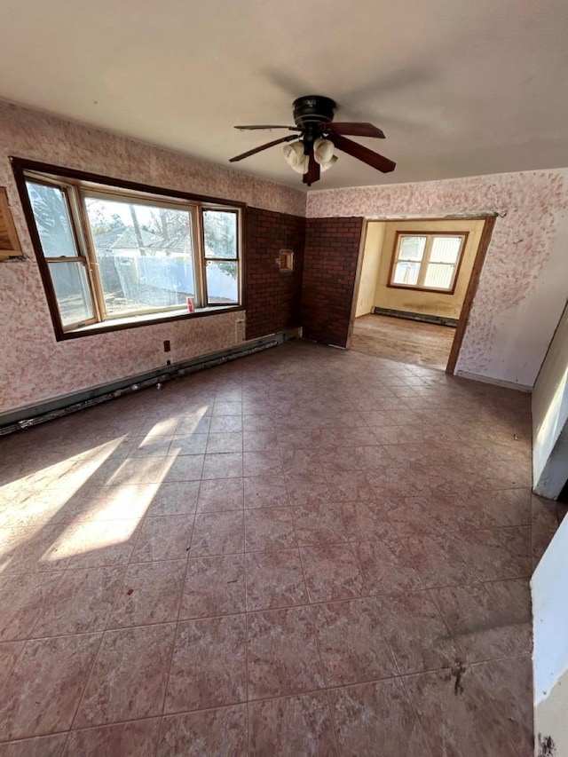 empty room featuring baseboard heating and ceiling fan