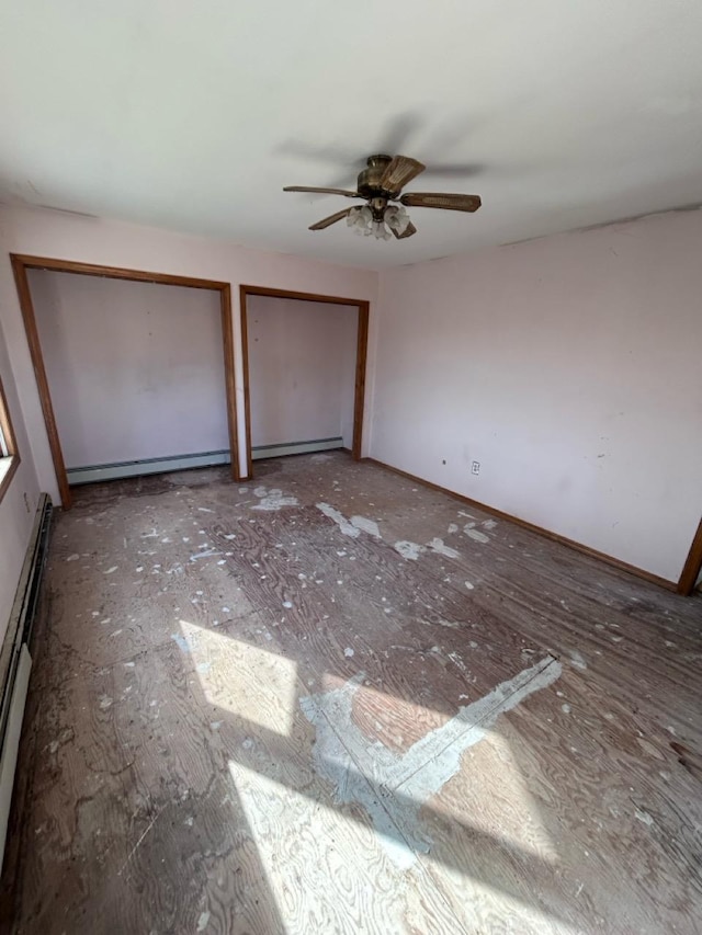 unfurnished bedroom with ceiling fan, a baseboard radiator, and two closets