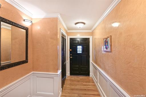 doorway to outside with crown molding and light hardwood / wood-style flooring