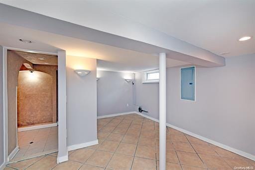 basement with light tile patterned flooring and electric panel