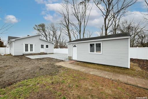 exterior space with a patio, an outdoor structure, and a lawn