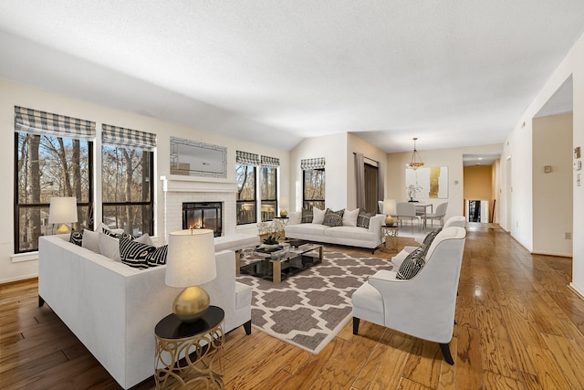 living room featuring hardwood / wood-style floors, a brick fireplace, and a textured ceiling