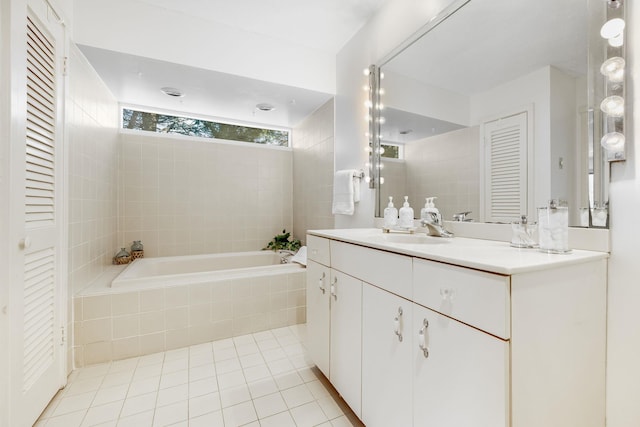 bathroom featuring tile patterned floors, vanity, and tiled tub