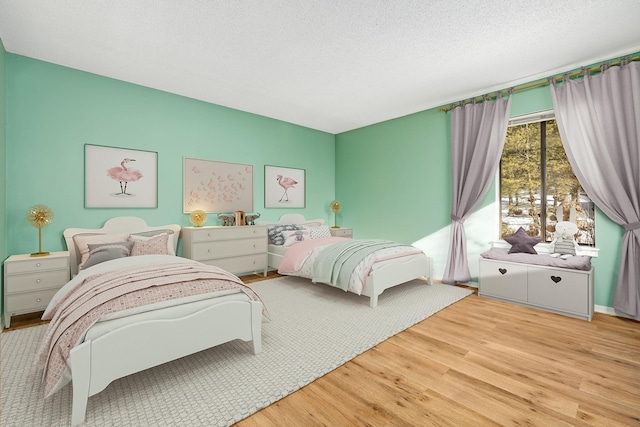 bedroom with a textured ceiling and light hardwood / wood-style floors