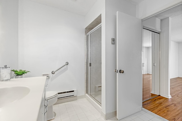 bathroom featuring a baseboard radiator, tile patterned floors, an enclosed shower, and vanity