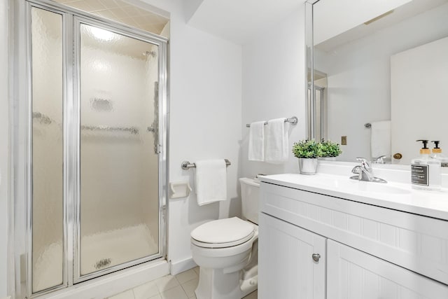 bathroom with tile patterned flooring, vanity, a shower with shower door, and toilet