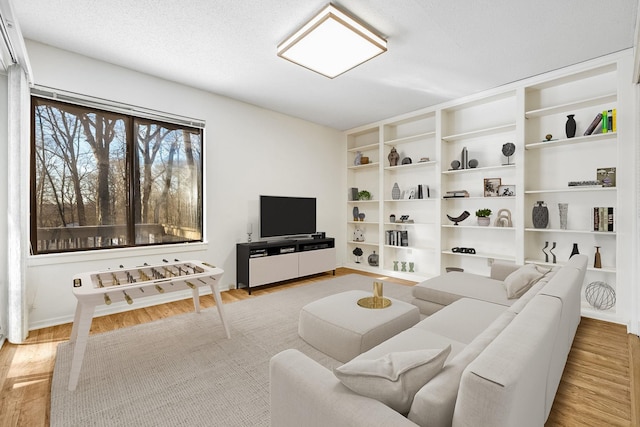 living room featuring a textured ceiling and light wood-type flooring