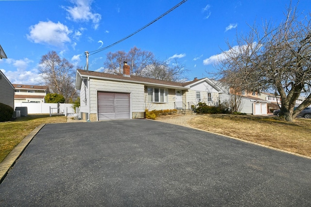 ranch-style house with a garage and a front lawn