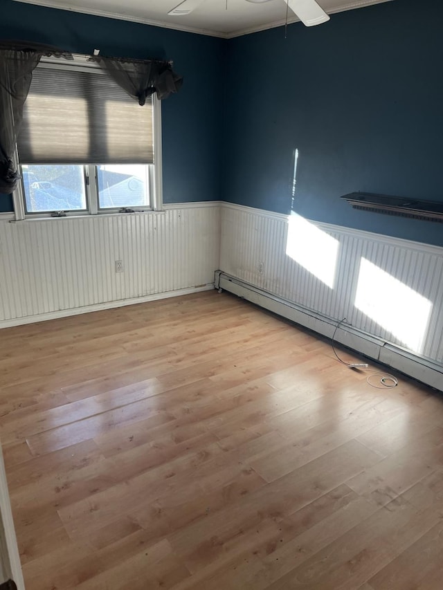 spare room featuring light wood-type flooring and baseboard heating