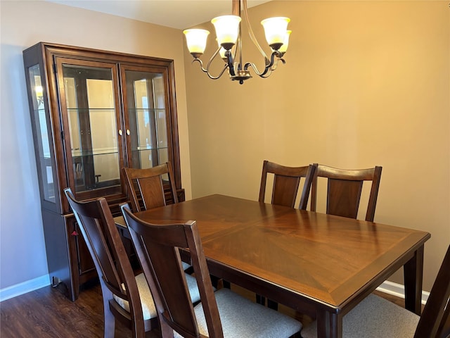 dining area with an inviting chandelier and dark hardwood / wood-style flooring