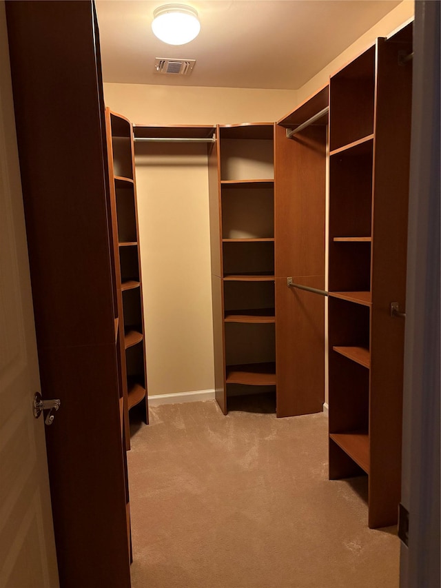 walk in closet featuring light colored carpet