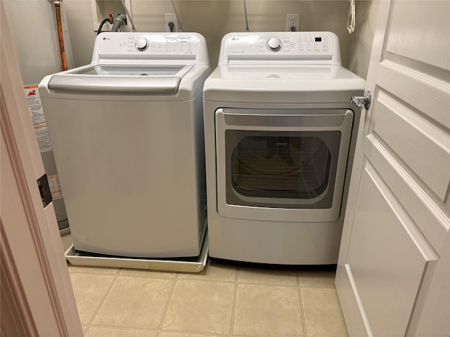 laundry room featuring light tile patterned flooring and washer and clothes dryer