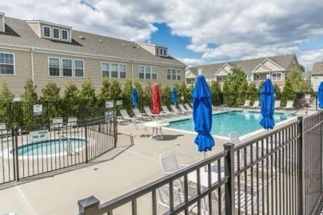 view of swimming pool featuring a hot tub and a patio