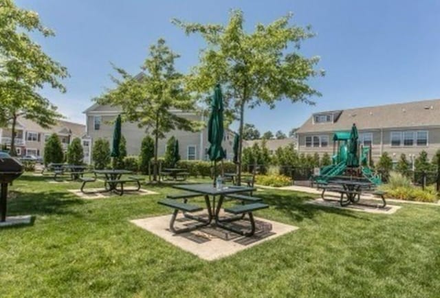 view of home's community with a playground and a yard