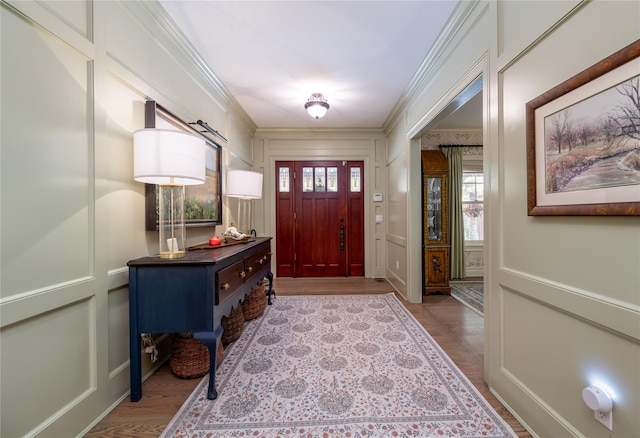 foyer entrance featuring ornamental molding and light wood-type flooring