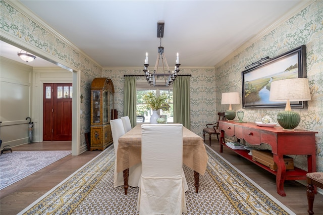 dining room featuring hardwood / wood-style floors, crown molding, and a chandelier