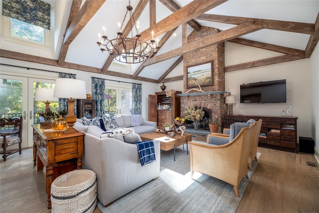 living room with hardwood / wood-style floors, a fireplace, french doors, and beamed ceiling