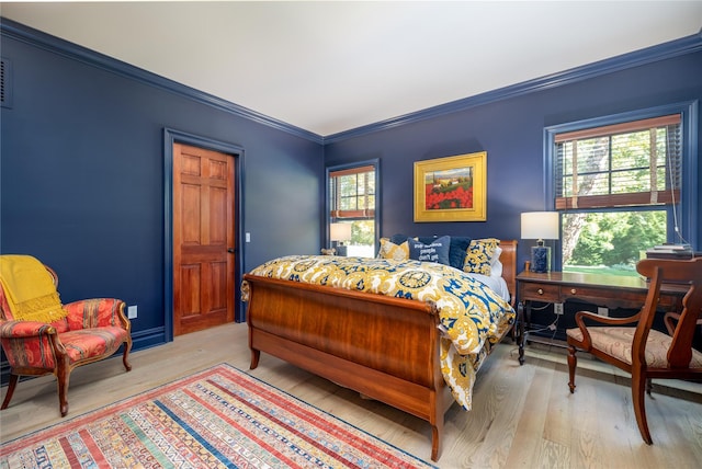 bedroom with ornamental molding and light hardwood / wood-style flooring