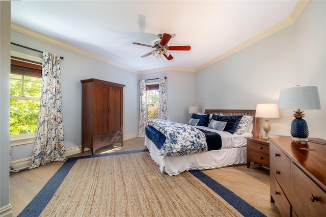 bedroom with crown molding, ceiling fan, and light hardwood / wood-style floors