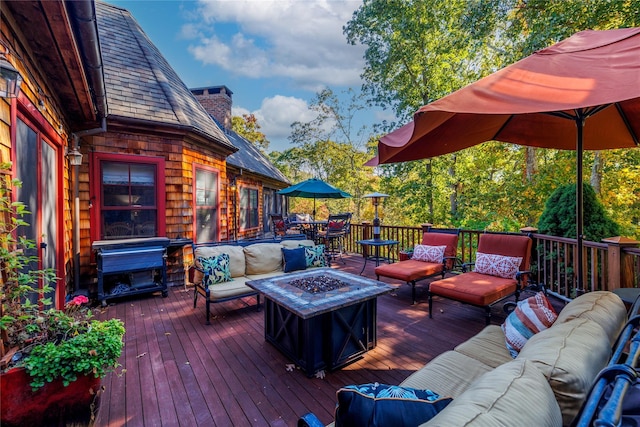 wooden terrace with an outdoor living space with a fire pit