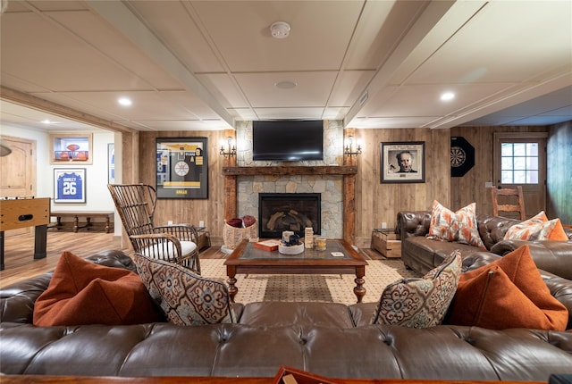 living room with wood-type flooring, wooden walls, and a fireplace