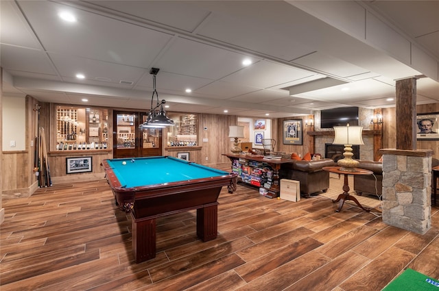 game room with hardwood / wood-style flooring, a large fireplace, bar area, a drop ceiling, and pool table