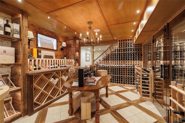 wine room with a notable chandelier, wood ceiling, and wooden walls