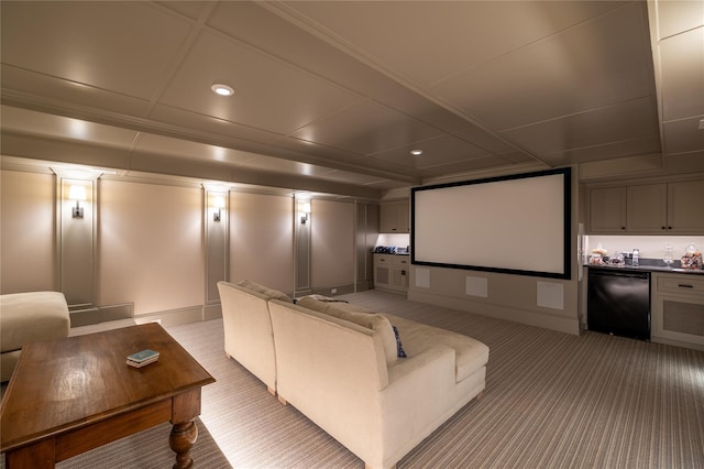 home theater room with decorative columns, ornamental molding, carpet, coffered ceiling, and bar