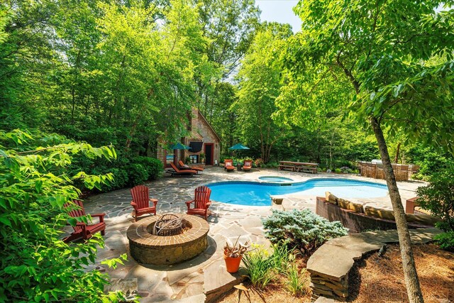 1750 Laurel Lake Dr, Mattituck, NY 11952 - swimming pool featuring an outdoor fire pit, an in-ground hot tub, a patio area, and an outbuilding