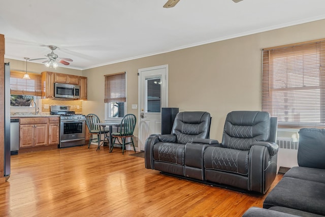 living room with a healthy amount of sunlight, light hardwood / wood-style floors, and ceiling fan