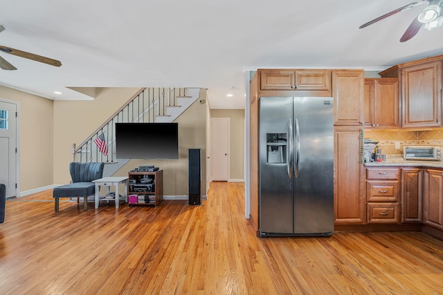 kitchen featuring stainless steel refrigerator with ice dispenser, ceiling fan, decorative backsplash, and light hardwood / wood-style flooring