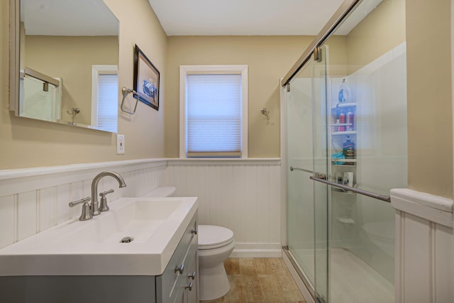 bathroom featuring vanity, toilet, an enclosed shower, and hardwood / wood-style floors