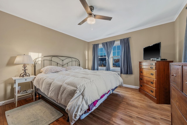 bedroom with crown molding, wood-type flooring, and ceiling fan