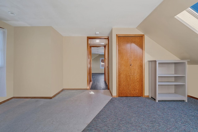 additional living space with carpet flooring and vaulted ceiling with skylight