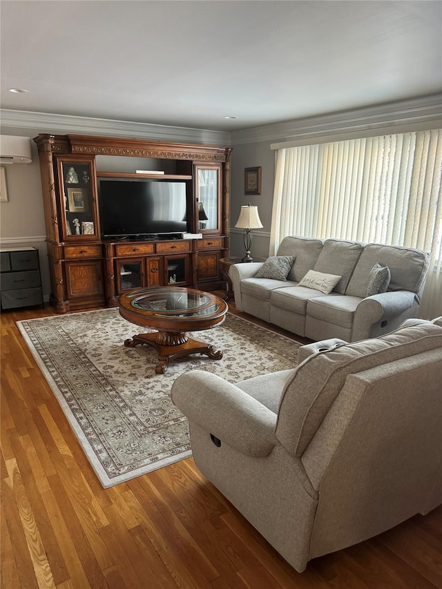 living room featuring hardwood / wood-style flooring, ornamental molding, and a wall mounted air conditioner