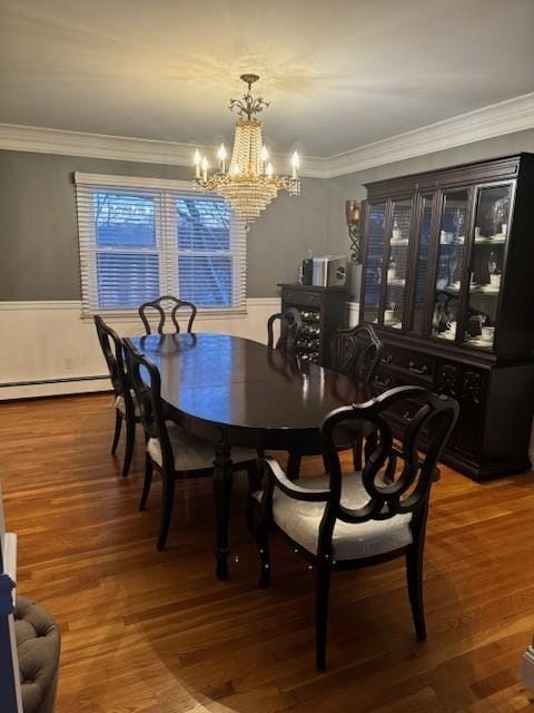 dining space featuring baseboard heating, ornamental molding, an inviting chandelier, and hardwood / wood-style flooring