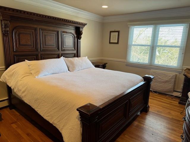 bedroom with crown molding and dark hardwood / wood-style flooring